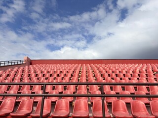 Fototapeta premium an open sports stadium with rows of red plastic seats without people