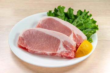 Fototapeta premium 豚肉のステーキ肉が白い皿に盛られた新鮮な食材