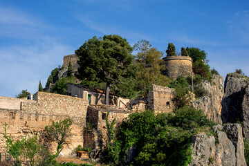 Fototapeta premium Xativa castle complex showcasing historic stone fortress walls and buildings on a rocky mountain under a clear blue sky