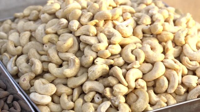 Abundant pile of raw, unsalted cashew nuts in a tray, healthy snack a detailed close up shot reveals large quantity