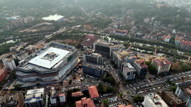 Cinematic aerial view of Panaji&rsquo;s Patto Centre showcasing modern commercial buildings, a prominent mall structure, and organized road networks with steady traffic.