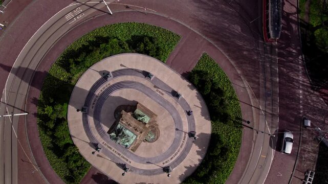 History and urban development suburb diplomatic neighbourhood of Den Haag, The Netherlands with tram and cars passing by on roundabout around the column with statues