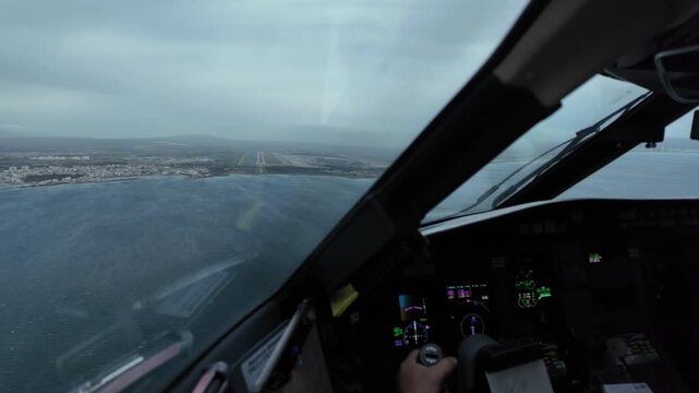immersive pilot&rsquo;s perspective through the windshield of a jet airplane flying through a thunderstorm in the final approach to Palma Airport, wiyh a view of pilot&rsquo;s hand on the controls.