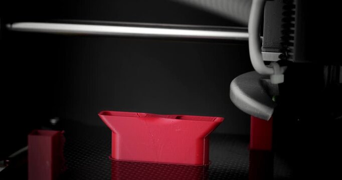Smooth timelapse of 3D printing fan duct on dark background.