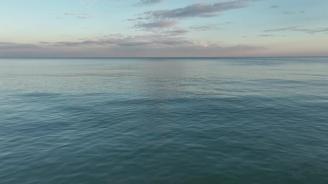 Video flight over ocean, sea on sunrise. Close to the water