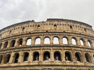 Obraz premium Iconic Roman Colosseum Exterior Under Dramatic Cloudy Sky in Rome Italy