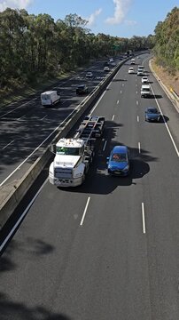 Daytime traffic time lapse on curving Sydney motorway through bushland