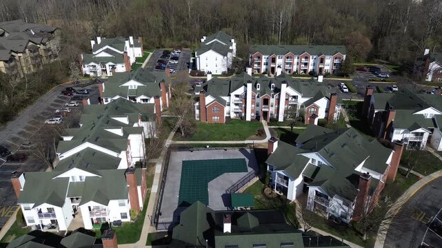 Poolcentered housing layout west of Paper Mill Rd near White Clay Creek, adjacent residential corridors. Green roofing, brick accents, covered pool surface, bright spring foliage, Newark, DE
