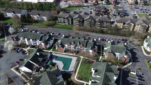 Centralpool apartment block west of Paper Mill Rd near White Clay Creek within residential zone. Green roofs, brick accents, covered pool surface, paved lots, bright seasonal foliage, Newark, DE