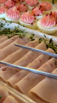 Gourmet deviled eggs with pink beet cream and red peppercorn served at a formal event buffet for luxury catering and elegant party food presentation or celebration. Vertical