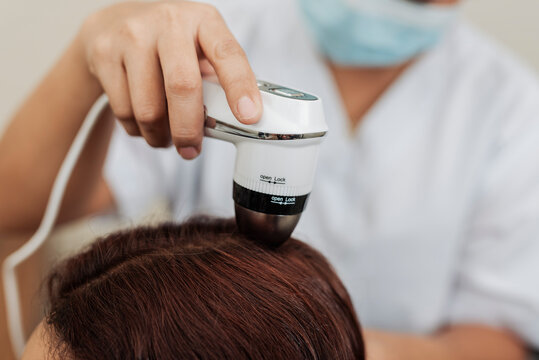 Trichologist using analyzer examining scalp and hair follicles at a head spa for scalp assessment, dandruff detection, oil analysis, and hair wellness treatment.