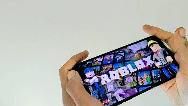 Jakarta, ID - May 11, 2026: Close Up Hand Hold Smartphone Playing Roblox Game