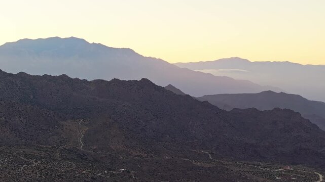 Palm Springs mountain range fading into horizon with soft evening sky colors, aerial drone overview