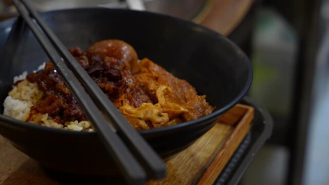 Steaming hot Lu Rou Fan, a traditional Taiwanese comfort food, served in a black bowl