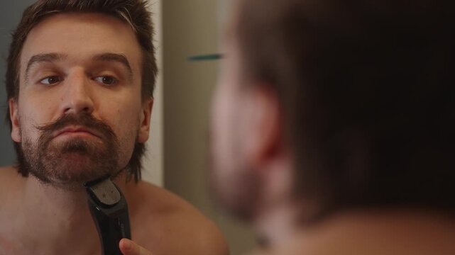 Over the shoulder shot of man shaving in mirror (4k60p)