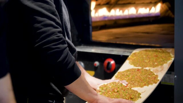 Man Preparing and baking pita kiymal pide and lahmacun. Turkish pizza video