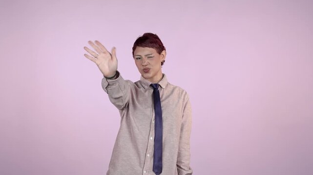 Androgynous person waving goodbye with a smile on pink background