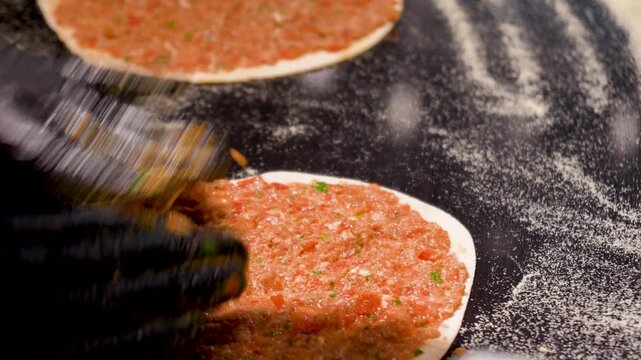 Man Preparing and baking pita kiymal pide and lahmacun. Turkish pizza video