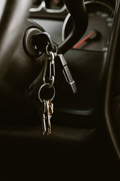 Car ignition key and multiple house keys hanging from a keychain