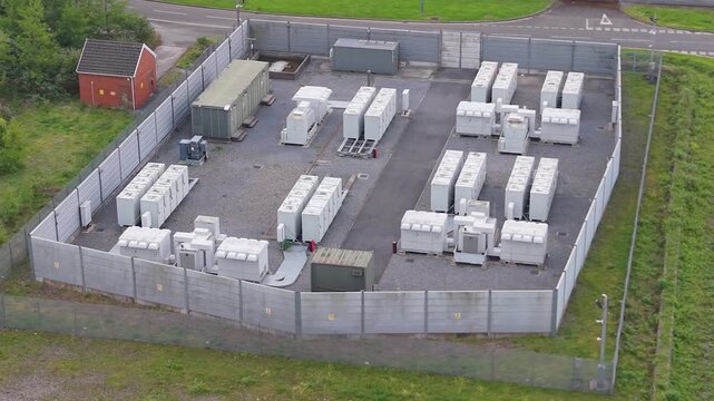 Aerial of BESS Battery Energy Storage Containers near Electrical Substation. Renewable Power Solutions for the Grid in South Wales, UK.