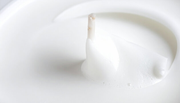 Close up of a melted white candle wax with a partially submerged wick