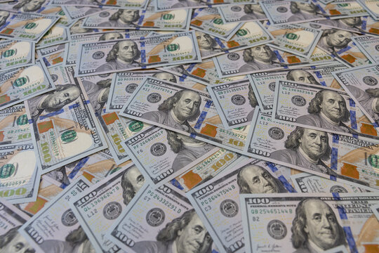 Background of many scattered one hundred US dollar bills