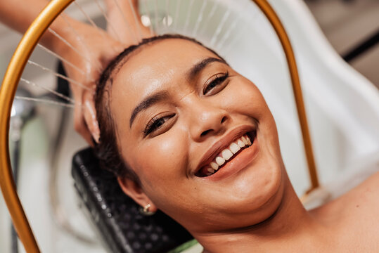 Smiling Southeast Asian woman enjoying aqua ring water halo scalp rinse at a Japanese head spa for relaxation, cleansing, and scalp hydration.