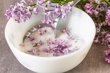Purple lilac flowers in sugar with fresh flowers and vintage spoon © DIA