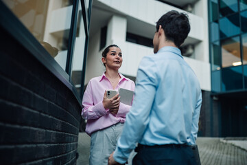 Fototapeta premium Business professionals having a discussion outdoors, collaborating and communicating during a casual meeting in the city