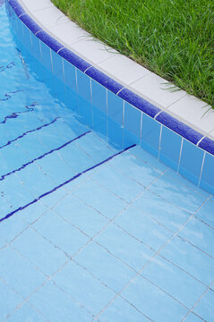 Blue pool filled with water in Summer