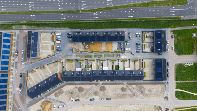 Aerial view of modern residential houses with solar panels on rooftops and parked cars in a new housing development Utrecht, Utrecht, Netherlands.