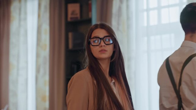 Young woman in library wearing glasses, contemplative researcher and curator roles across frames, warm natural light, vintage interior, books and shelf backdrop, formal blazer, long brown hair,