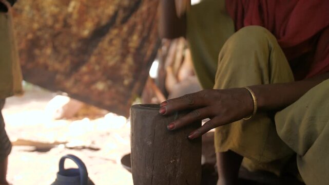 Une femme met de la poudre de caf&eacute; dans une cafeti&egrave;re typique pour la cuisiner, en Ethiopie