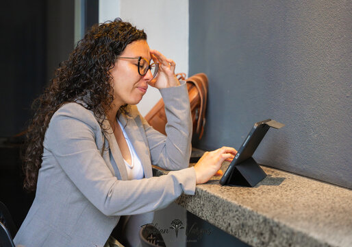 Exhausted businesswoman having headache stressing over tablet work
