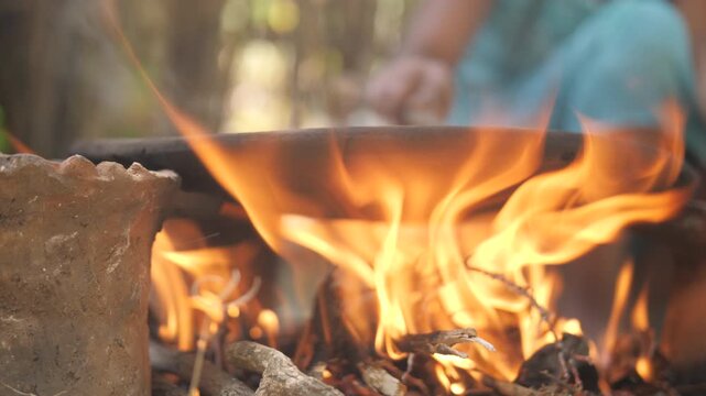 Une femme fait cuire des grains de caf&eacute; dans une casserole au-dessus d&rsquo;un feu ext&eacute;rieur, en &Eacute;thiopie 