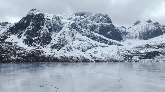 Stortvatnet on Austvagoya in Vagan Nordland Norway lies beneath Vagekallen massif with sharp glacial ridges and cirques carved in Precambrian rock, drone lateral slide right to left