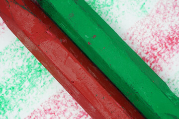 Close-up of colorful pastel chalk sticks on textured background. Artistic composition featuring red and green drawing pastels with vibrant powder texture