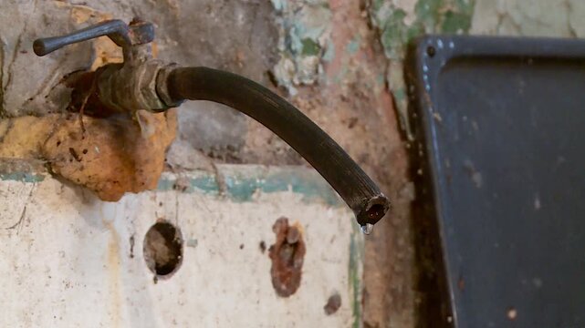 water drips from the faucet in the slums