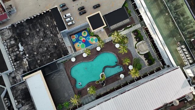 A view from above the swimming pool in the hotel area and the tropical gardens at an urban resort.