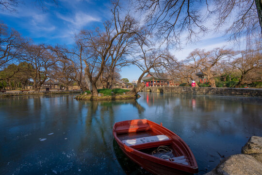Beautiful daytime landscape of the historic Gwanghallu Pavilion and its traditional wooden structures overlooking a scenic pond with a bright blue sky in Namwon.