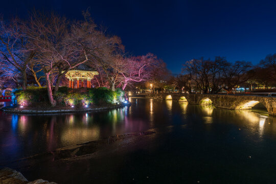 Serene twilight view of the illuminated Gwanghallu Pavilion overlooking a calm pond surrounded by bare winter trees and glowing ground lanterns in Namwon.
