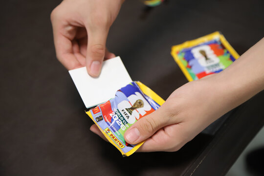 Person opening a pack of stickers for the 2026 FIFA World Cup. Panini sticker pack	
