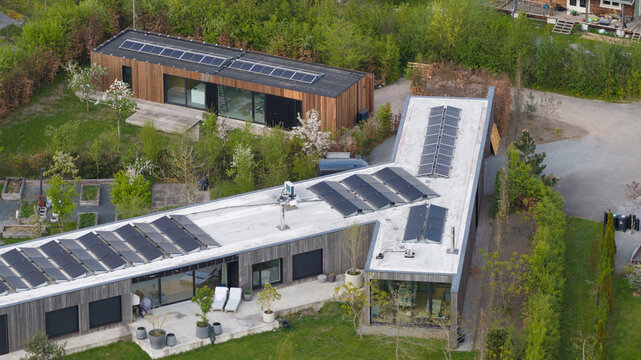 Aerial view of Ecodorp Bolderburen featuring modern wooden houses with solar panels on flat roofs and lush gardens in Almere, Flevoland, Netherlands.