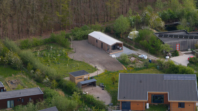 Aerial view of Ecodorp Bolderburen featuring modern sustainable wooden houses with solar panels and lush green gardens in Almere, Flevoland, Netherlands.
