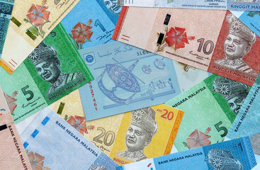 Malaysian ringgit money banknotes pile on table. Malaysia bills of MYR currency close up © Larysa