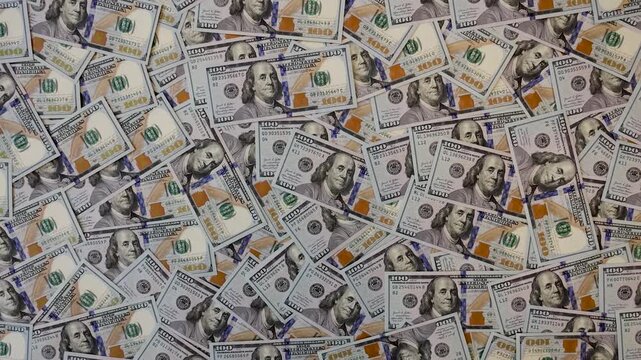 Zoom out from background of many scattered one hundred US dollar bills