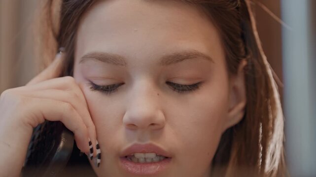 Young woman speaking assertively on phone, closeup reaction shots with expressive mouth and subtle sighs, visible nail art and studio lighting, dynamic facial cues during important negotiation, candid