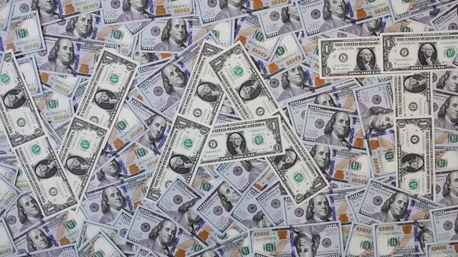 Zoom out from word VAT made of one dollar bills on hundred dollar banknotes
