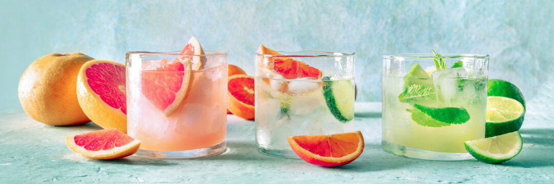 Refreshing summer cocktails with ice cubes on a light background