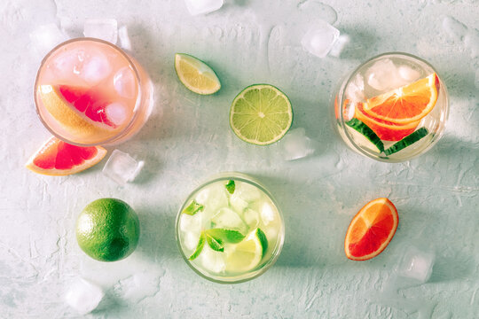 Refreshing summer cocktails with ice cubes on a light background